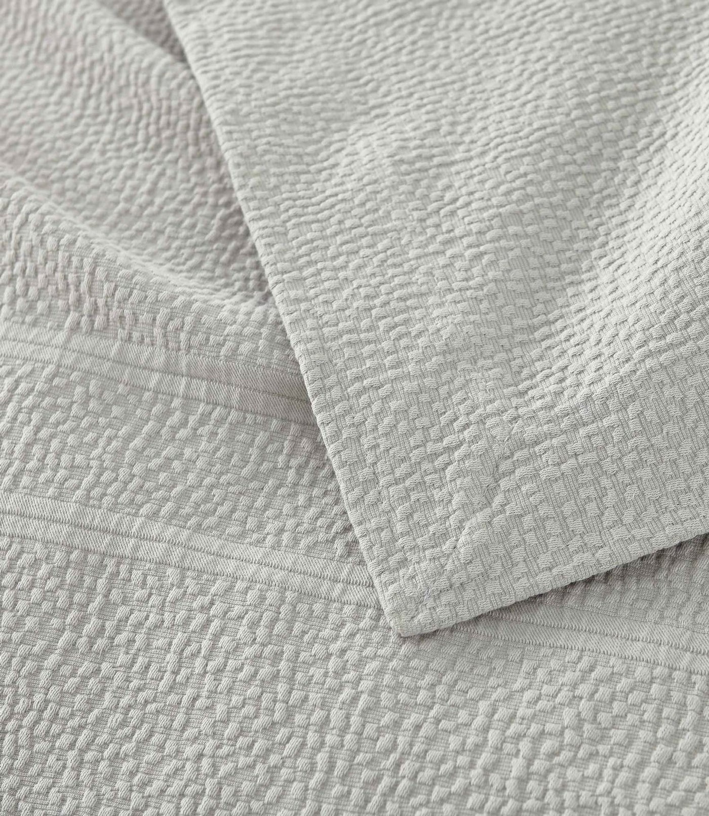 Montauk Matelassé Coverlet corner detail in Gray – pebble texture – Peacock Alley